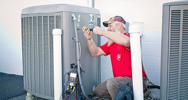 Comfort Control employee working on an outside HVAC unit